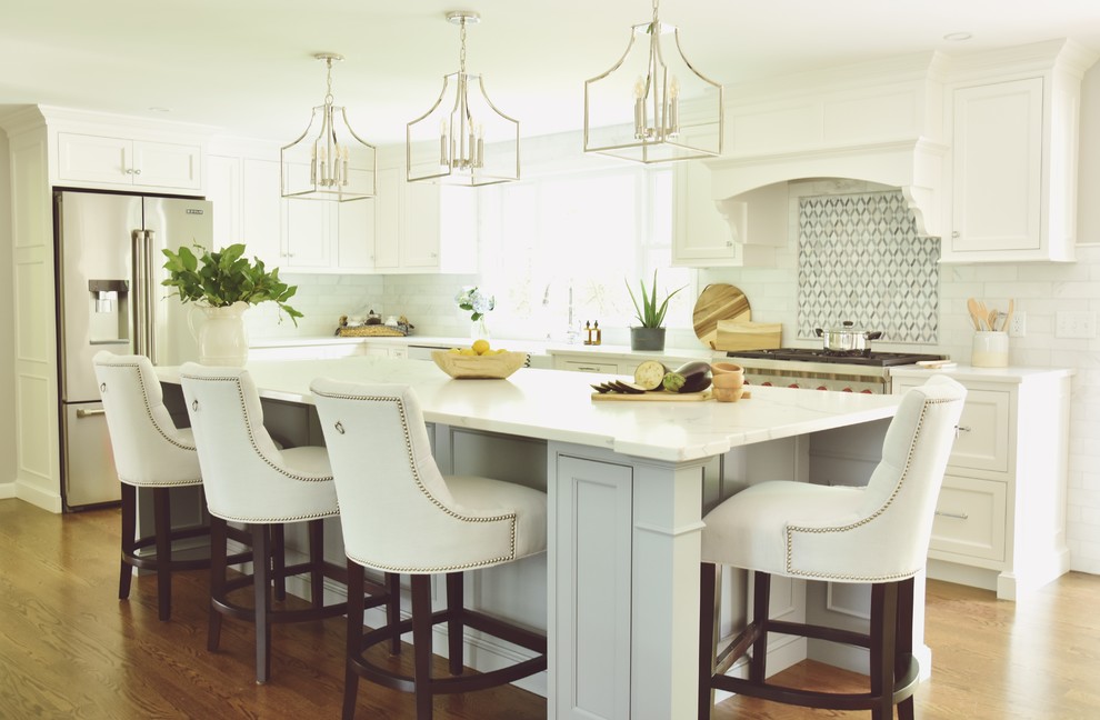 Inspiration for a traditional kitchen in Boston with a farmhouse sink, beaded inset cabinets, quartz benchtops, white splashback, marble splashback, stainless steel appliances, dark hardwood floors, with island and white benchtop.