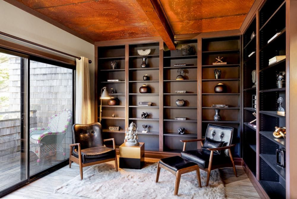 Bild på ett litet funkis arbetsrum, med ett bibliotek, vita väggar, mellanmörkt trägolv och brunt golv