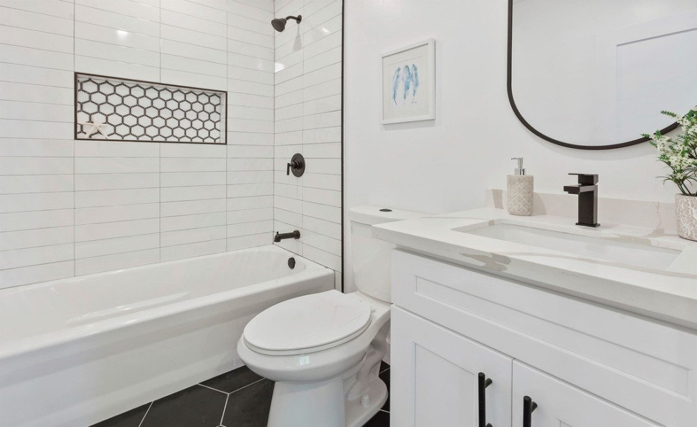 This is an example of a bathroom in Los Angeles with shaker cabinets, white cabinets, an alcove bath, a shower/bath combination, a one-piece toilet, white walls, ceramic flooring, a submerged sink, marble worktops, white floors, a shower curtain, white worktops, a wall niche, a single sink and a built in vanity unit.
