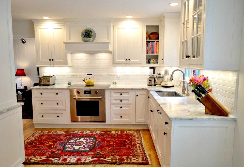 Inspiration for a small country l-shaped eat-in kitchen in Bridgeport with a single-bowl sink, recessed-panel cabinets, white cabinets, marble benchtops, white splashback, subway tile splashback, stainless steel appliances, light hardwood floors, no island and beige floor.