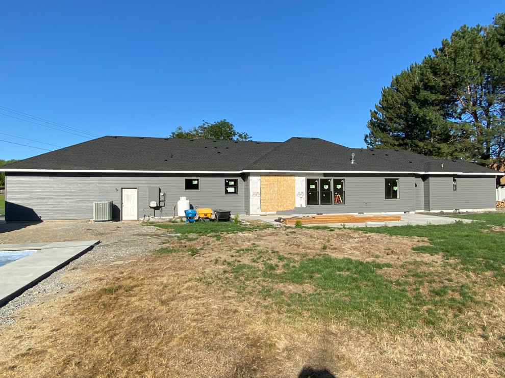 Example of a huge transitional multicolored one-story concrete and board and batten house exterior design with a hip roof, a shingle roof and a black roof