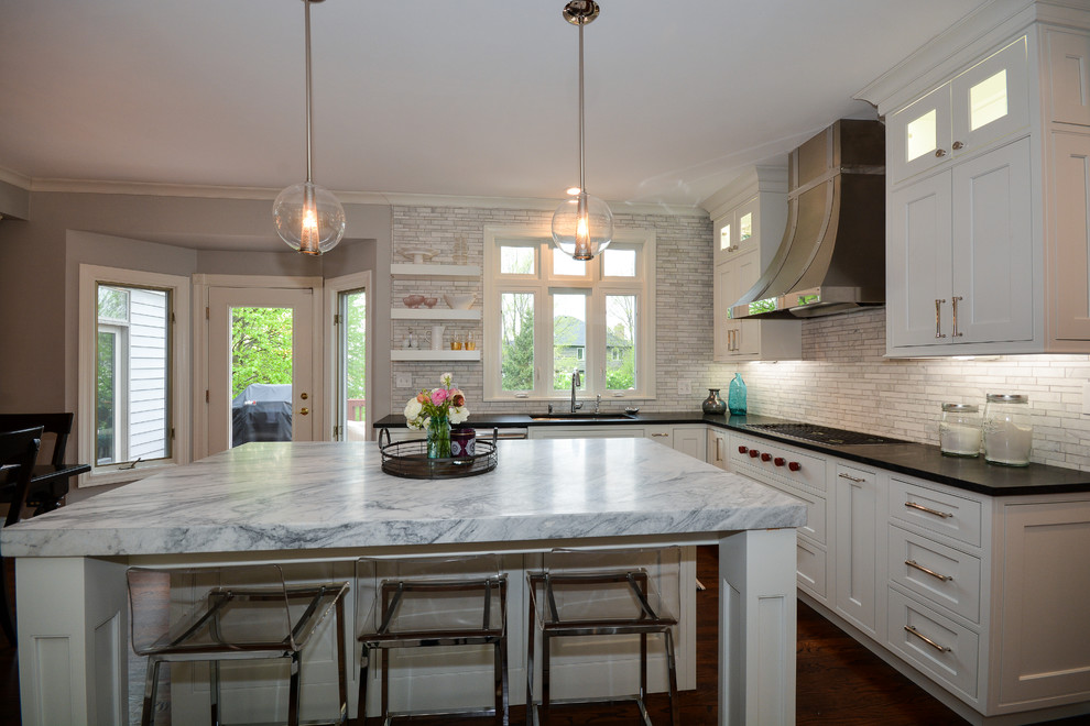 Large transitional u-shaped dark wood floor and brown floor eat-in kitchen photo in Chicago with an undermount sink, recessed-panel cabinets, white cabinets, soapstone countertops, gray backsplash, marble backsplash, stainless steel appliances and an island