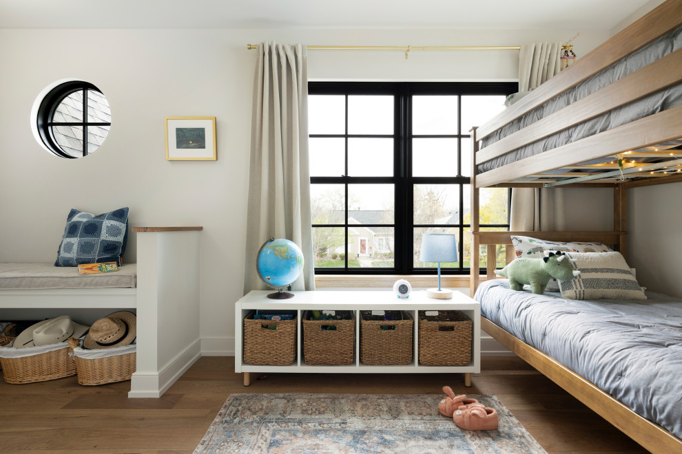 Example of a mid-sized transitional medium tone wood floor and brown floor kids' room design in Minneapolis with white walls