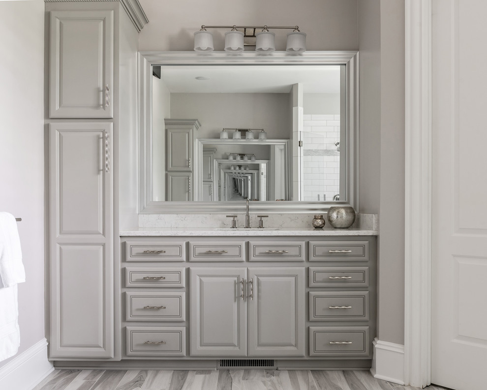 Inspiration for a large transitional master bathroom in Charlotte with grey cabinets, a freestanding tub, a curbless shower, gray tile, terra-cotta tile, grey walls, porcelain floors, an undermount sink, engineered quartz benchtops, grey floor, a hinged shower door and grey benchtops.