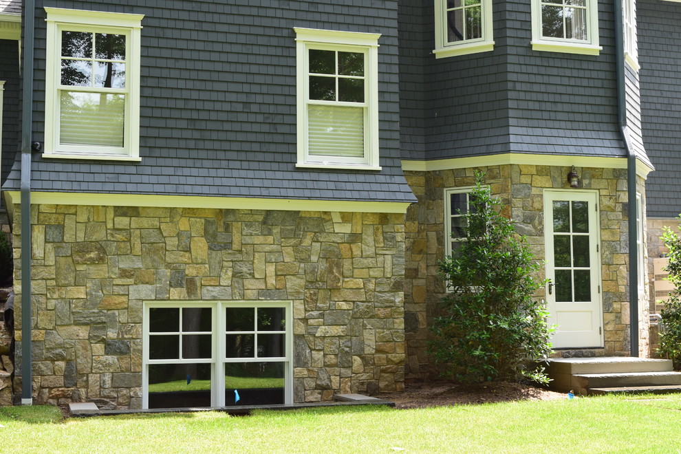 Large traditional two-storey blue exterior in New York with stone veneer.
