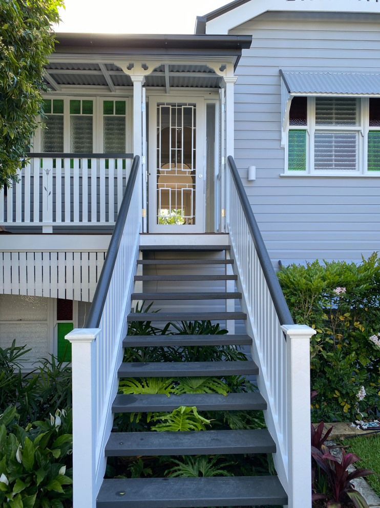 Große Moderne Haustür mit grauer Wandfarbe, gebeiztem Holzboden, Einzeltür, weißer Haustür, braunem Boden, freigelegten Dachbalken und Holzdielenwänden in Brisbane