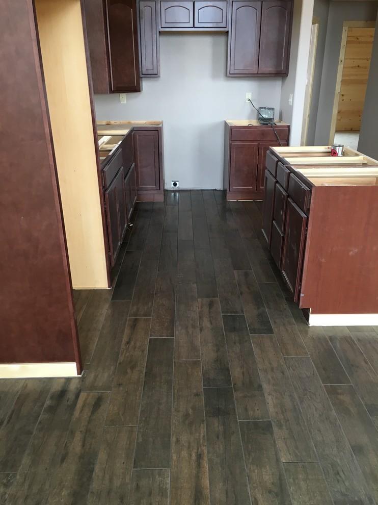 Home design - large rustic l-shaped porcelain tile home design idea with flat-panel cabinets, dark wood cabinets and an island