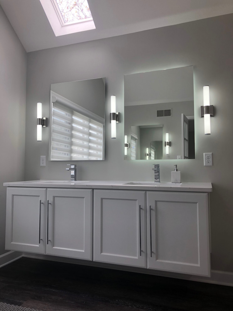 Photo of a mid-sized modern master bathroom in Other with flat-panel cabinets, white cabinets, a freestanding tub, a corner shower, a one-piece toilet, white tile, ceramic tile, white walls, porcelain floors, an undermount sink, engineered quartz benchtops, beige floor, an open shower, white benchtops, a niche, a double vanity and a built-in vanity.