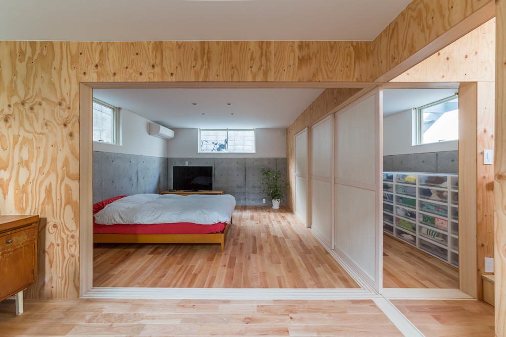 Ejemplo de dormitorio asiático con paredes multicolor y suelo de madera clara