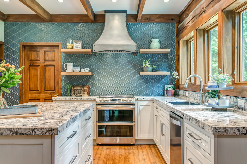 Inspiration for a country l-shaped eat-in kitchen in Nashville with beaded inset cabinets, white cabinets, quartz benchtops, blue splashback, stainless steel appliances, light hardwood floors, with island and multi-coloured benchtop.