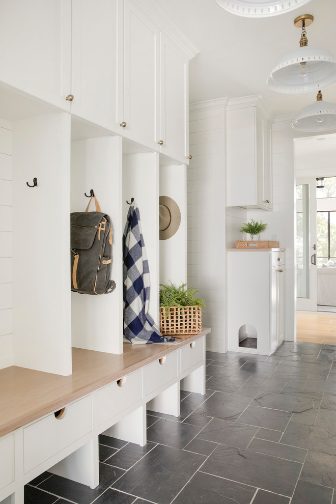 Inspiration for a country mudroom in Minneapolis with white walls and black floor.
