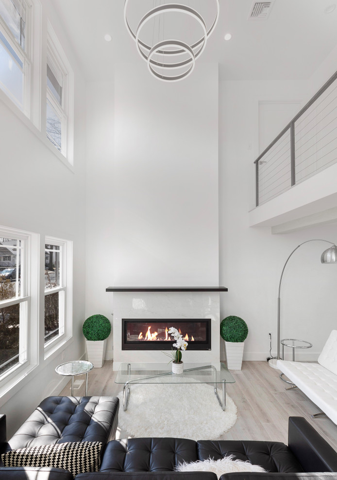 Modern Residential Construction - Inspiration for a large modern formal and loft-style light wood floor, brown floor, vaulted ceiling and wall paneling living room remodel in Newark with white walls, a standard fireplace, a wood fireplace surround and a wall-mounted tv