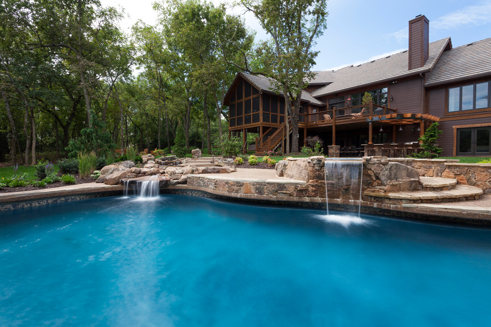 Design ideas for a large arts and crafts backyard custom-shaped pool in Kansas City with a hot tub and concrete slab.