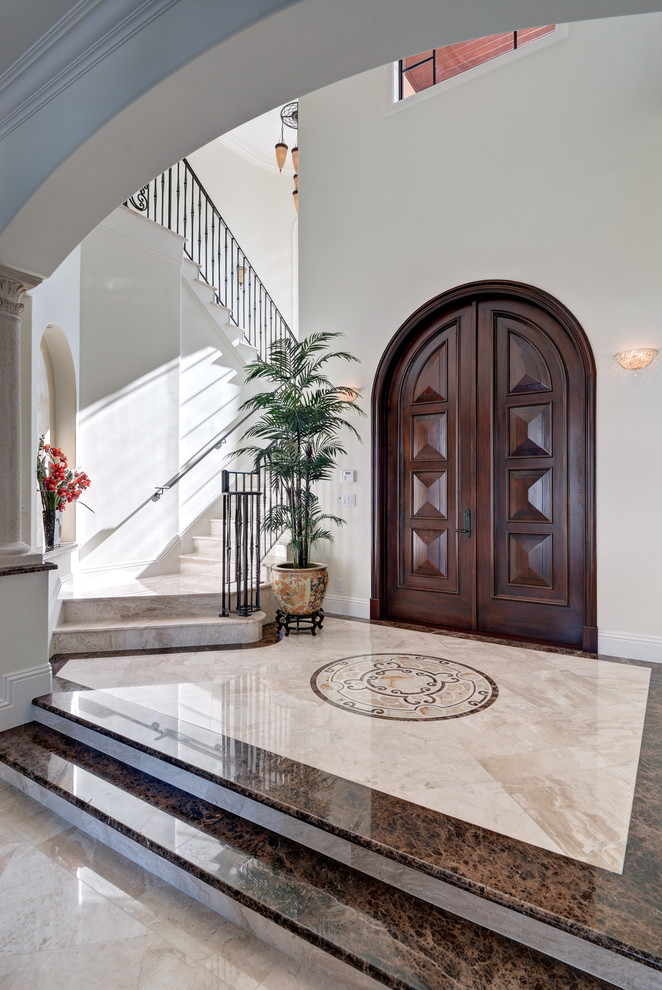 Inspiration for a mediterranean foyer in Miami with white walls, marble floors, a double front door and a dark wood front door.