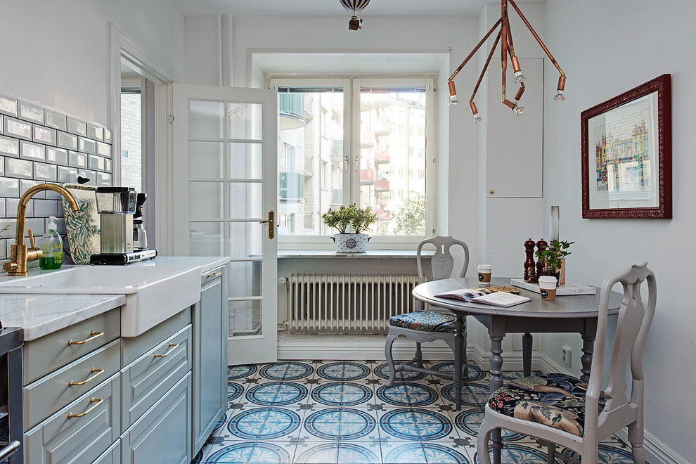 Design ideas for a mid-sized scandinavian single-wall eat-in kitchen in Gothenburg with a farmhouse sink, raised-panel cabinets, grey cabinets, grey splashback, subway tile splashback, marble benchtops, ceramic floors and no island.