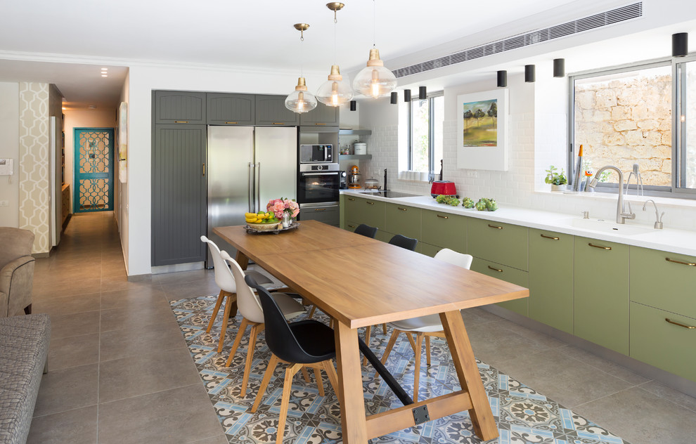 Photo of a country l-shaped kitchen in Other with flat-panel cabinets, green cabinets, white splashback, subway tile splashback and with island.
