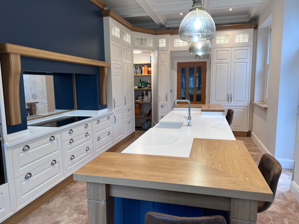 Inspiration for a large traditional l-shaped eat-in kitchen in Manchester with a farmhouse sink, beaded inset cabinets, white cabinets, solid surface benchtops, linoleum floors, with island, white benchtop and coffered.