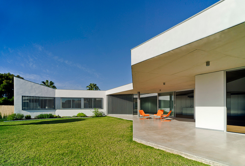 Diseño de terraza contemporánea de tamaño medio en patio trasero y anexo de casas