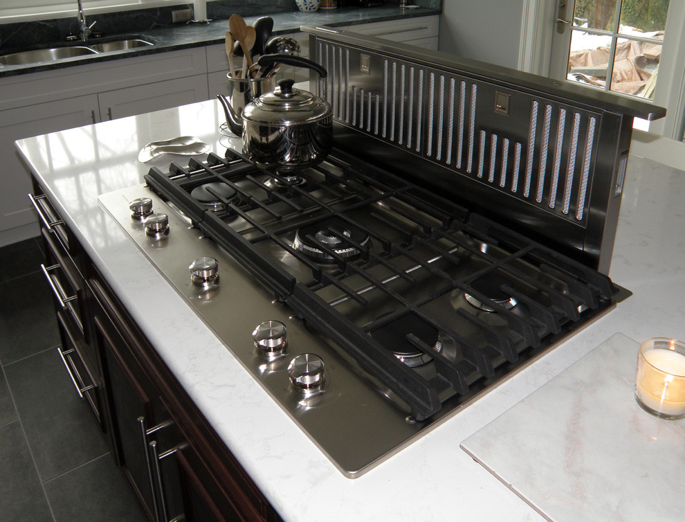 Example of a large transitional l-shaped ceramic tile enclosed kitchen design in Baltimore with an undermount sink, shaker cabinets, white cabinets, soapstone countertops, green backsplash, glass tile backsplash, stainless steel appliances and an island