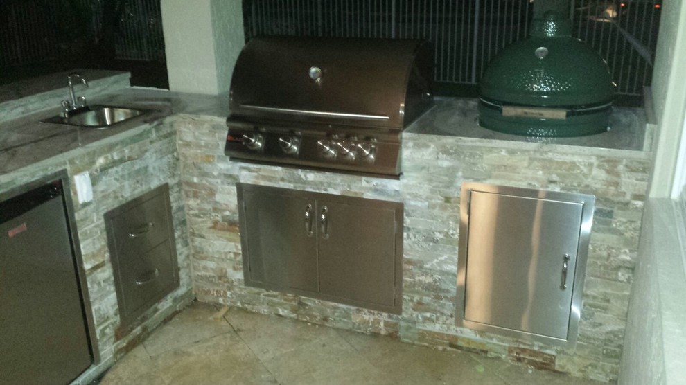 Photo of a large traditional backyard patio in Miami with an outdoor kitchen.