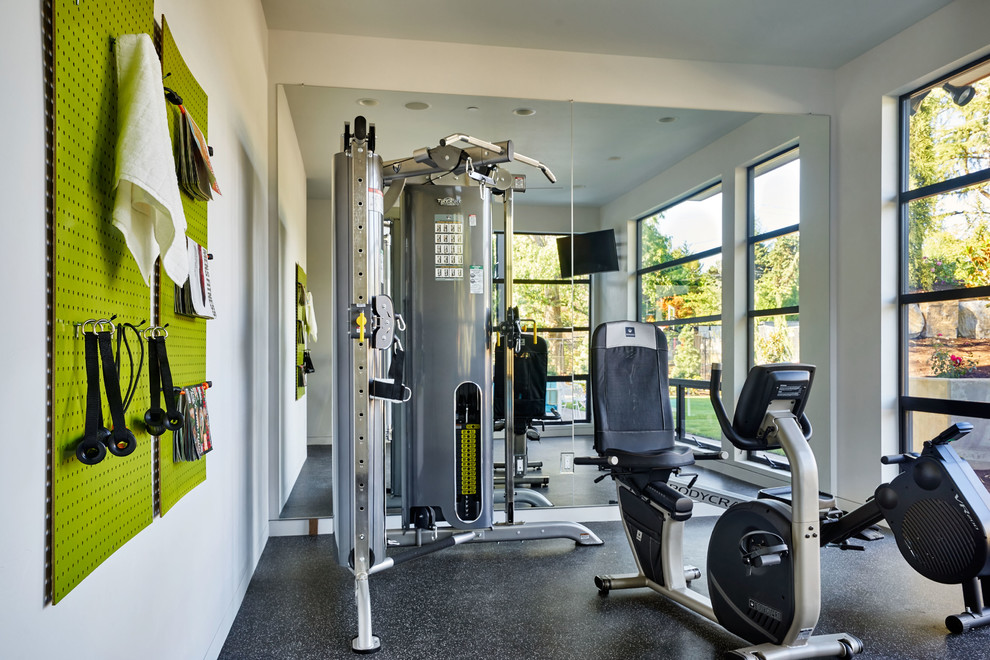 This is an example of a large contemporary home weight room in Portland with white walls.