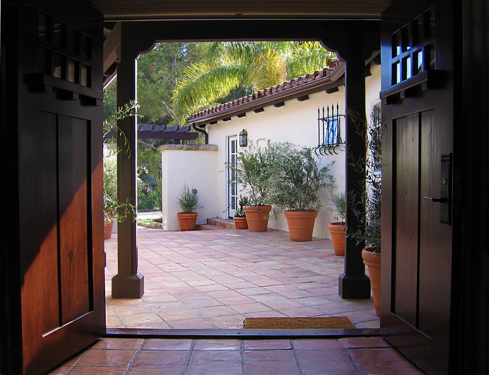 This is an example of a small mediterranean courtyard full sun garden for summer in Santa Barbara with a container garden and brick pavers.