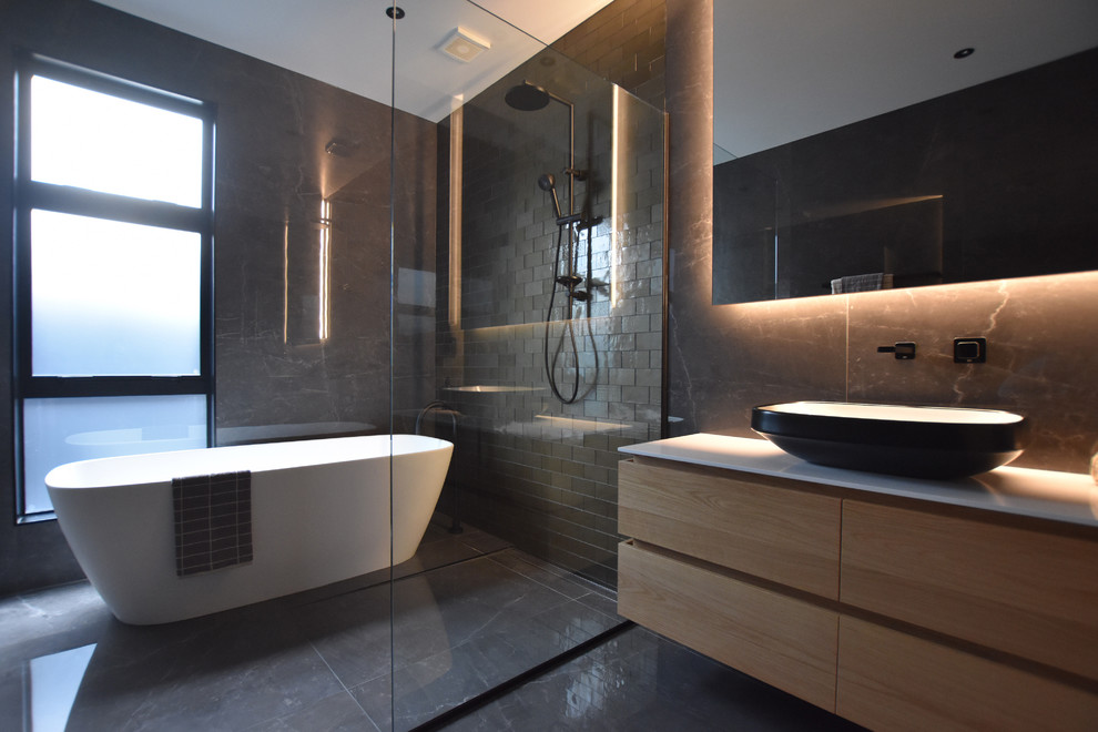 Design ideas for a contemporary wet room bathroom with light wood cabinets, brown tile, an open shower and white benchtops.