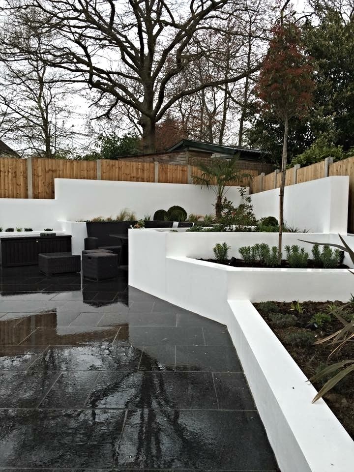 Photo of a mid-sized contemporary backyard full sun formal garden for summer in Essex with natural stone pavers.