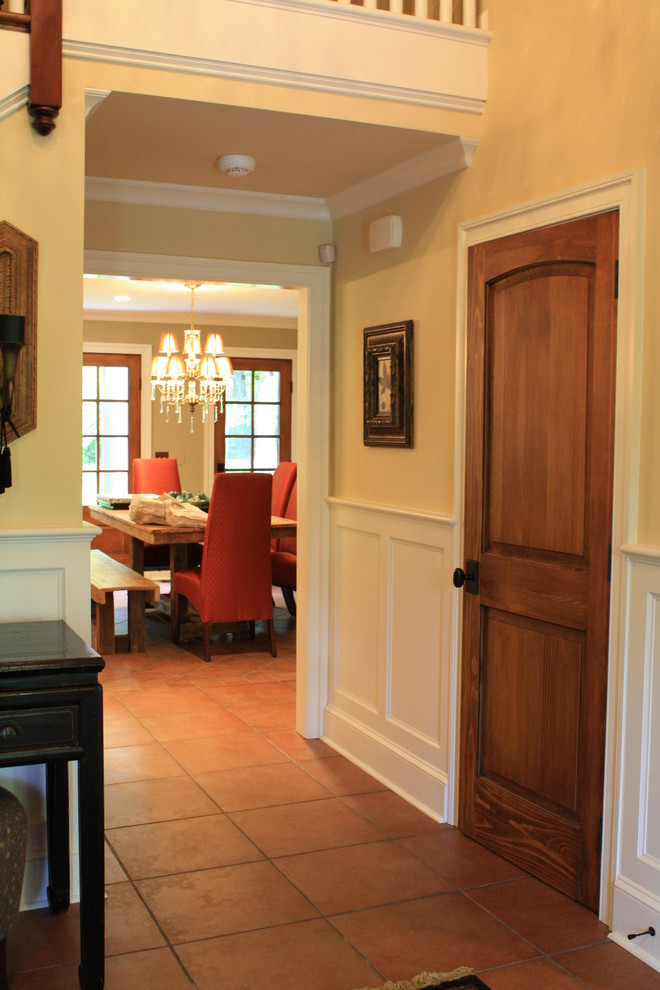 Photo of a mid-sized traditional foyer in Philadelphia with yellow walls, terra-cotta floors and a dark wood front door.