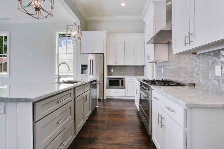 Inspiration for a contemporary kitchen in New Orleans with a single-bowl sink, shaker cabinets, grey cabinets, marble benchtops, grey splashback, stainless steel appliances, dark hardwood floors and with island.