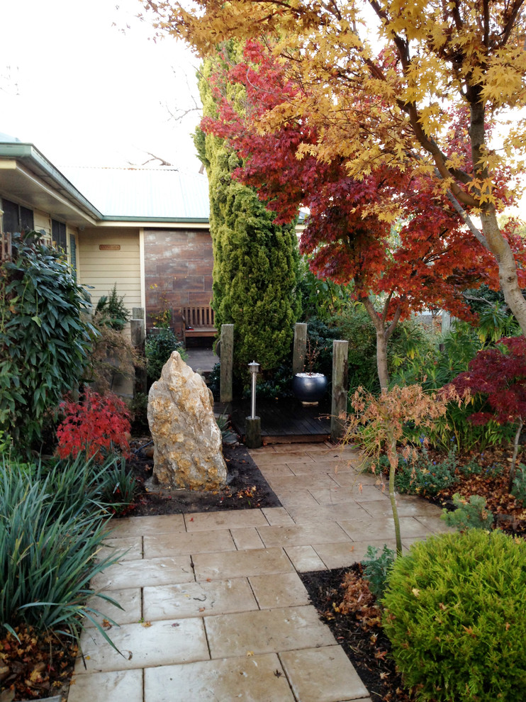 This is an example of a large asian front yard partial sun formal garden in Canberra - Queanbeyan with natural stone pavers.