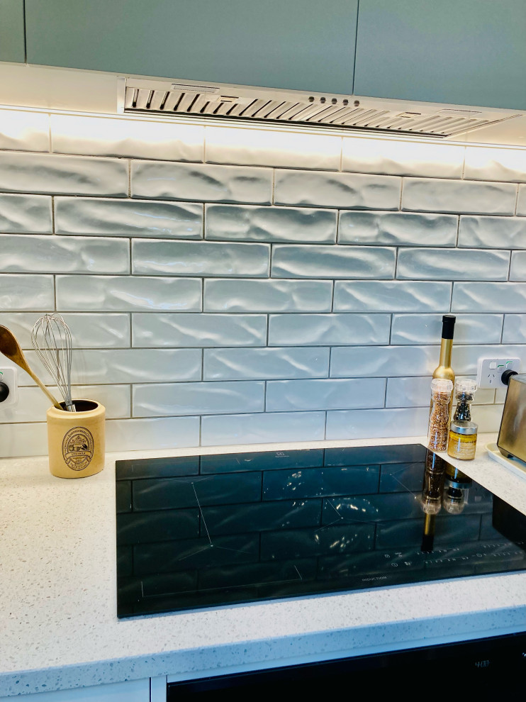 This is an example of a large contemporary kitchen in Christchurch with quartz benchtops, white splashback, porcelain splashback and white benchtop.