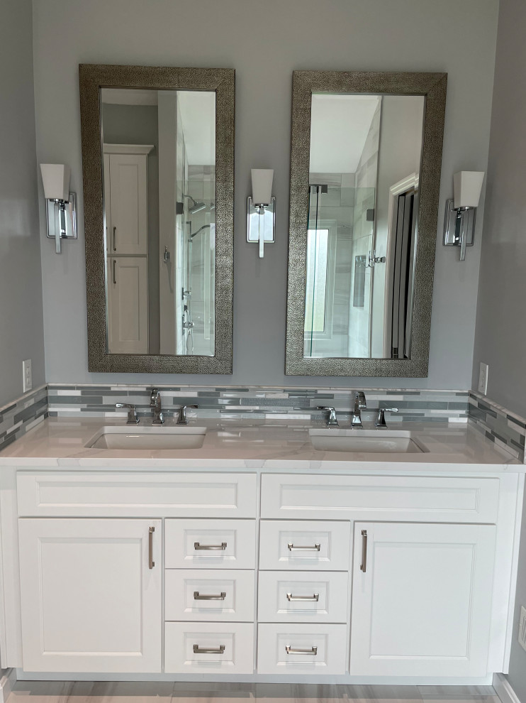 Example of a mid-sized transitional master gray tile and porcelain tile porcelain tile, gray floor, double-sink and vaulted ceiling alcove shower design in Cincinnati with recessed-panel cabinets, white cabinets, an undermount sink, quartz countertops, a hinged shower door, white countertops and a built-in vanity