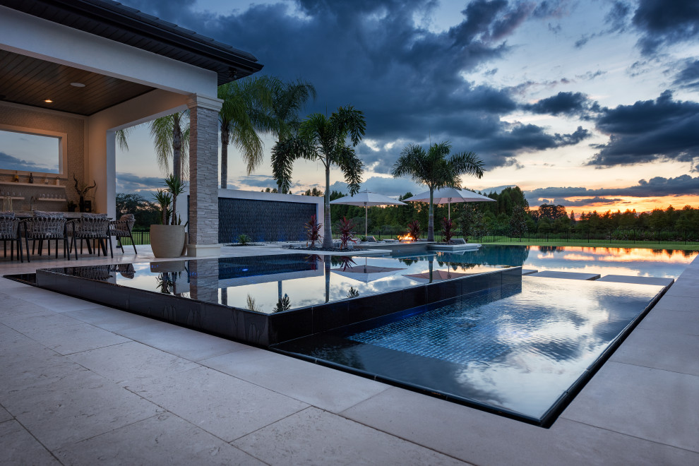 Ispirazione per un'ampia piscina moderna dietro casa con piastrelle