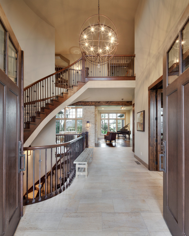 Photo of a large mediterranean entry hall in Kansas City with beige walls, porcelain floors and a dark wood front door.