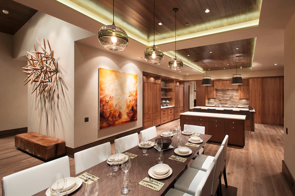 This is an example of a contemporary u-shaped eat-in kitchen in Denver with medium wood cabinets, brown splashback and panelled appliances.