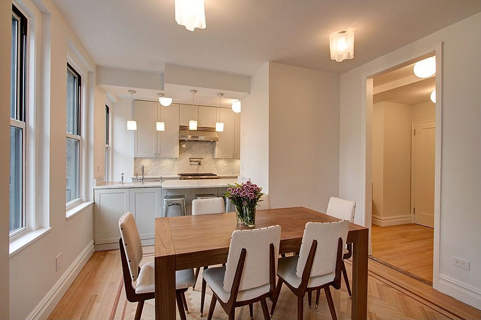 Inspiration for a mid-sized transitional kitchen/dining combo in New York with white walls, light hardwood floors and no fireplace.