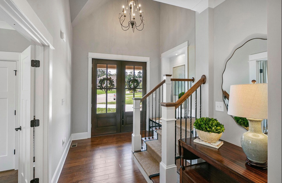Entryway - mid-sized traditional medium tone wood floor, brown floor and vaulted ceiling entryway idea in Other with gray walls and a dark wood front door
