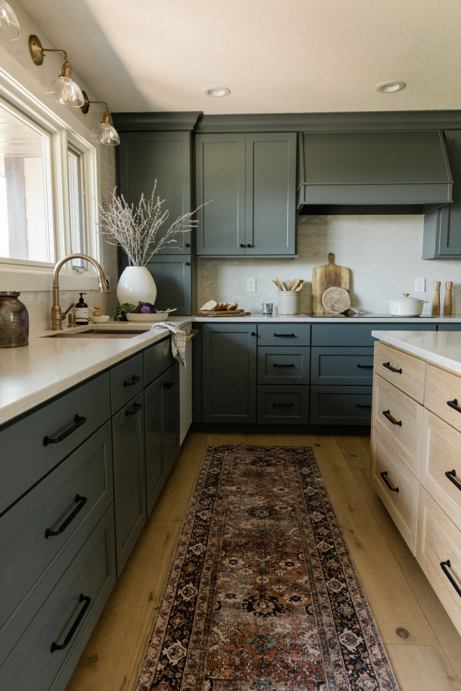 Inspiration for a traditional u-shaped kitchen in Other with a submerged sink, white splashback, white appliances, light hardwood flooring, an island and white worktops.