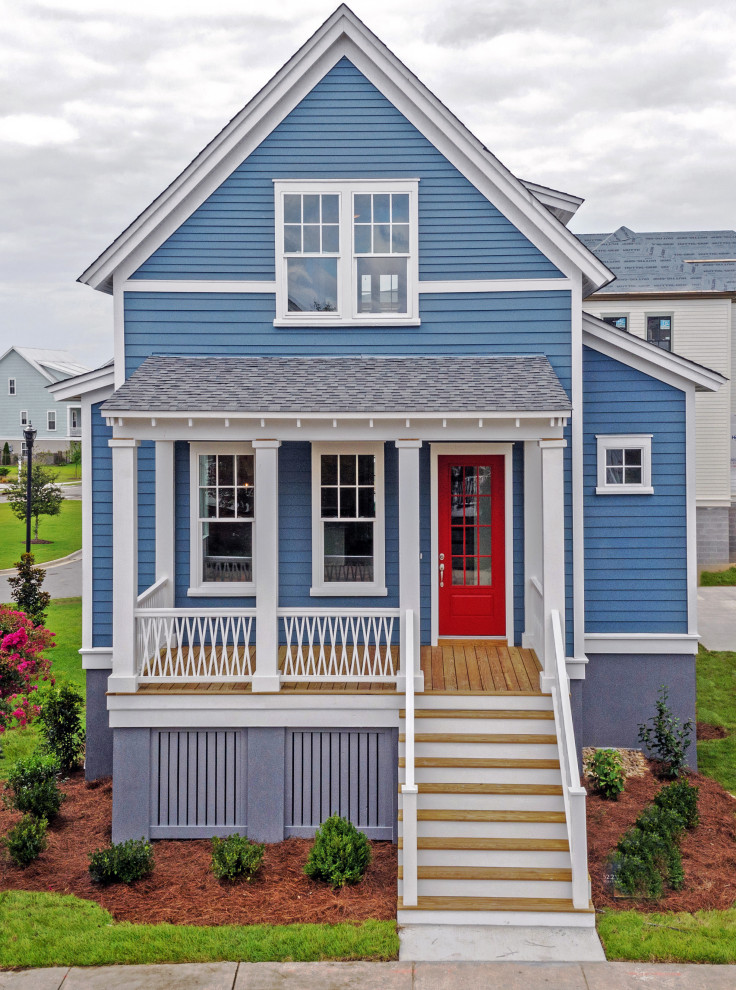 Свежая идея для дизайна: двухэтажный, синий частный загородный дом среднего размера в морском стиле с облицовкой из бетона, двускатной крышей, крышей из гибкой черепицы, черной крышей и отделкой планкеном - отличное фото интерьера