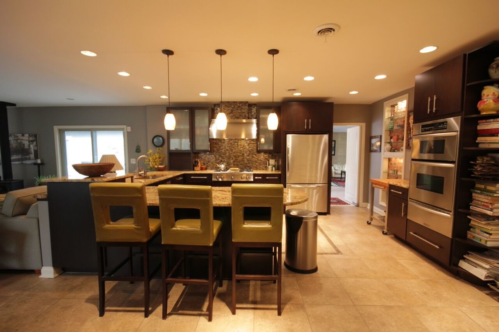 Photo of a mid-sized modern u-shaped eat-in kitchen in Columbus with flat-panel cabinets, brown cabinets, granite benchtops, glass tile splashback, stainless steel appliances, carpet, with island, beige floor, an undermount sink and metallic splashback.