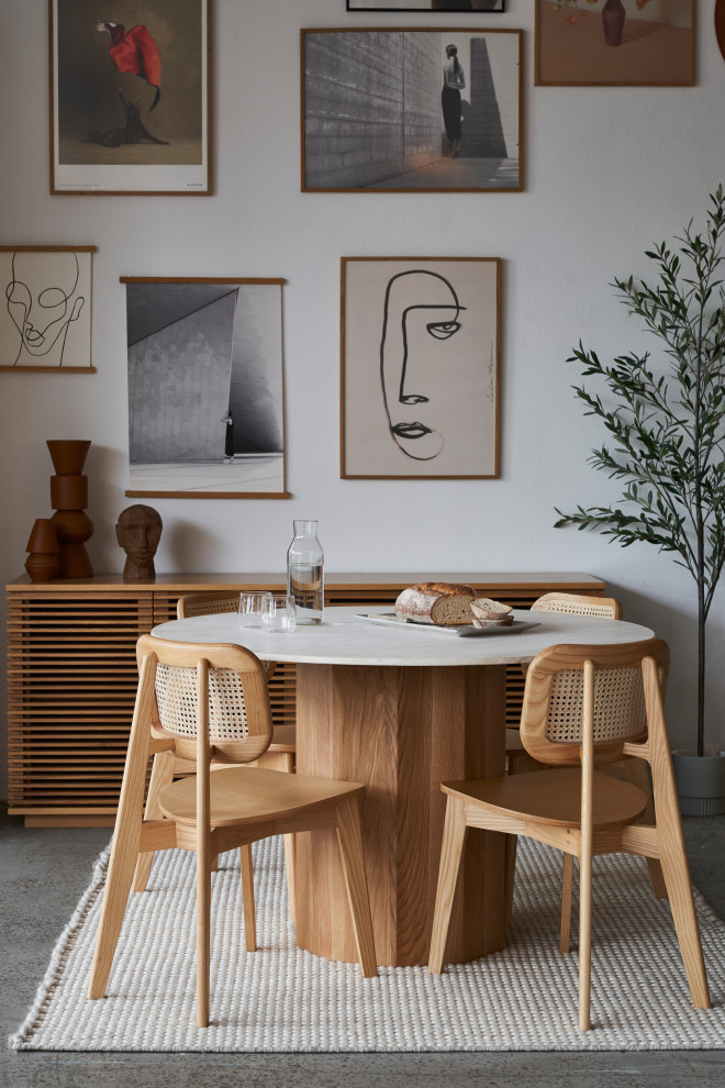Стильный дизайн: столовая в современном стиле с белыми стенами, бетонным полом и серым полом - последний тренд