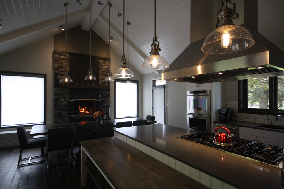 Example of a large transitional l-shaped vaulted ceiling eat-in kitchen design with shaker cabinets and an island