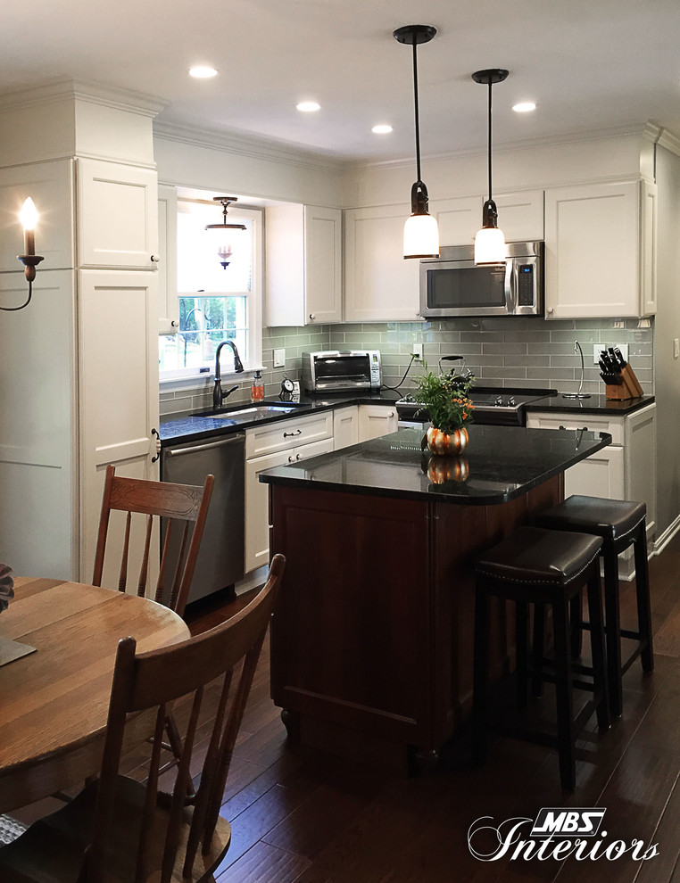 Eat-in kitchen - mid-sized transitional l-shaped medium tone wood floor and brown floor eat-in kitchen idea with an undermount sink, white cabinets, granite countertops, gray backsplash, subway tile backsplash, stainless steel appliances, an island and recessed-panel cabinets