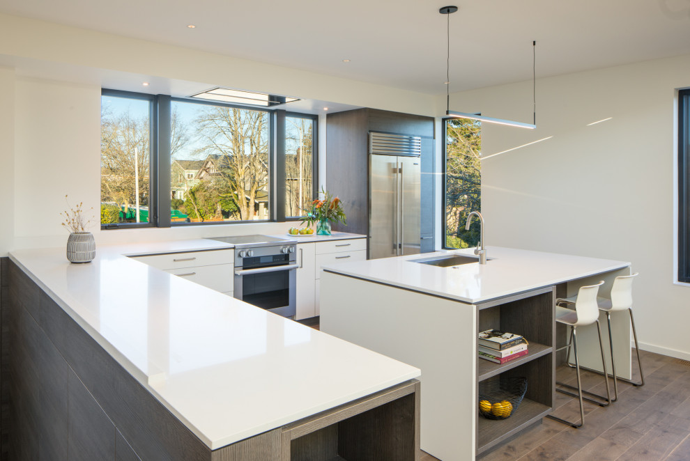Medium sized contemporary l-shaped open plan kitchen in Seattle with flat-panel cabinets, white cabinets and white worktops.