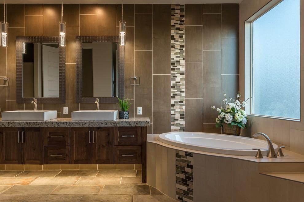 Inspiration for a mid-sized contemporary master bathroom in Other with shaker cabinets, dark wood cabinets, a corner tub, multi-coloured tile, mosaic tile, grey walls, ceramic floors, a vessel sink, granite benchtops and brown floor.