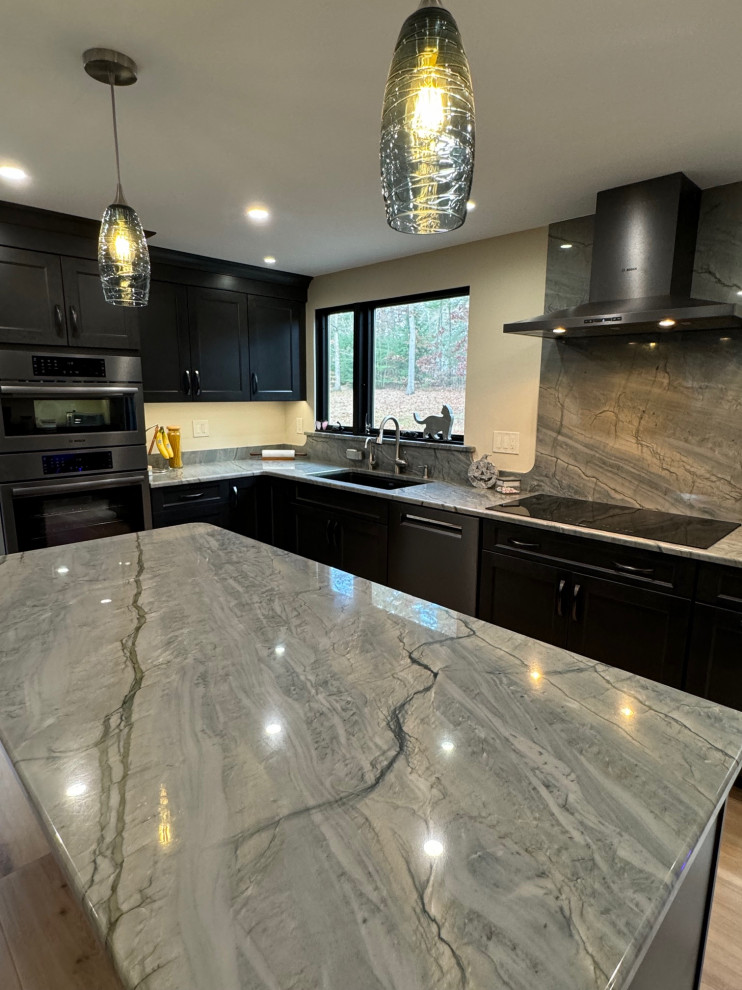 Example of a mid-sized transitional u-shaped laminate floor and brown floor eat-in kitchen design in Boston with an undermount sink, shaker cabinets, brown cabinets, quartz countertops, black appliances, an island and multicolored countertops