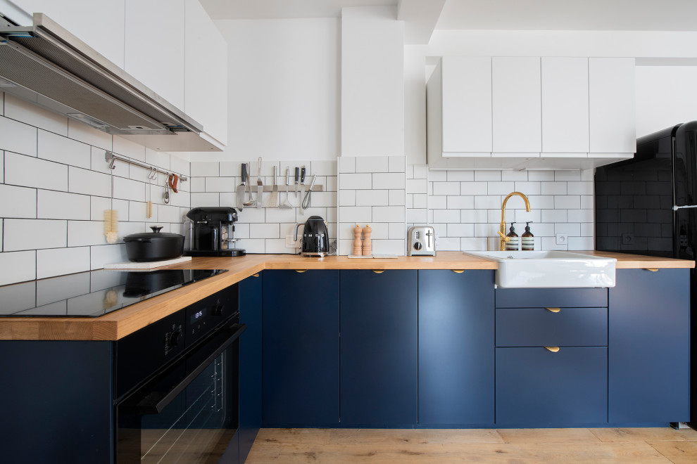 Inspiration for a mid-sized scandinavian single-wall open plan kitchen in Paris with a single-bowl sink, flat-panel cabinets, blue cabinets, wood benchtops, white splashback, cement tile splashback, coloured appliances, light hardwood floors, multiple islands, beige floor and beige benchtop.