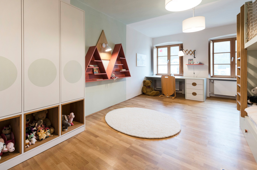 Großes Modernes Mädchenzimmer mit grüner Wandfarbe, braunem Holzboden und braunem Boden in Sonstige