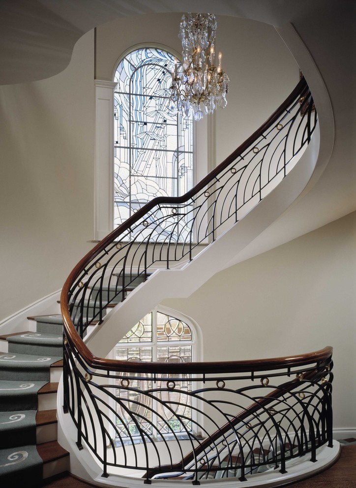 This is an example of a large traditional wood curved staircase in Houston with painted wood risers and mixed railing.